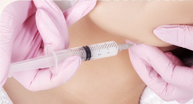 분홍색 장갑을 낀 의료진이 환자의 턱 라인에 주사를 시술하는 모습